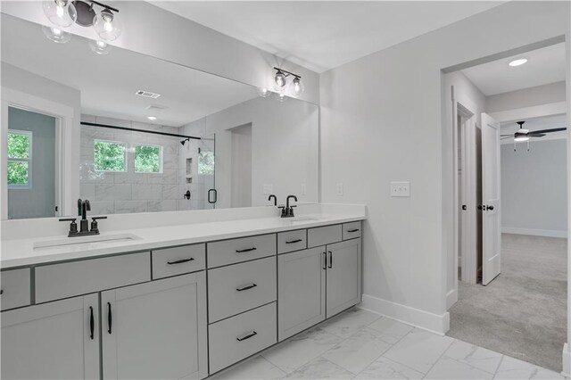 bathroom featuring a shower with door, ceiling fan, and vanity