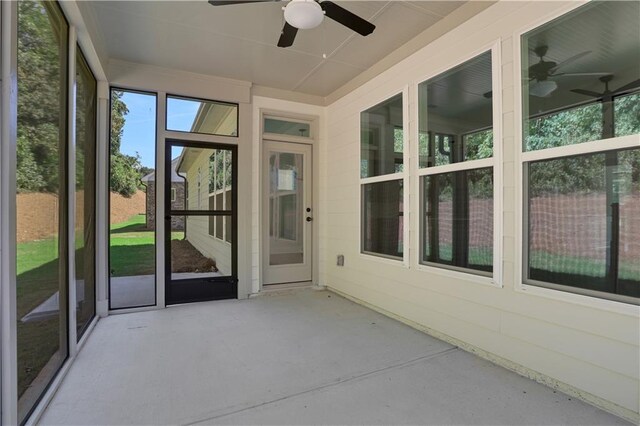 unfurnished sunroom featuring ceiling fan