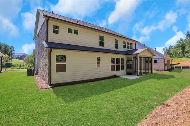 back of house with a yard, a sunroom, and central AC