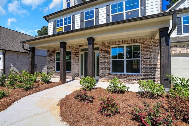 exterior space featuring covered porch and a garage