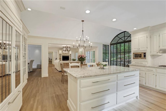 2562 Red Valley Rd, Atlanta, GA 30305 - kitchen with stainless steel microwave, light wood-style floors, light stone counters, and a kitchen island
