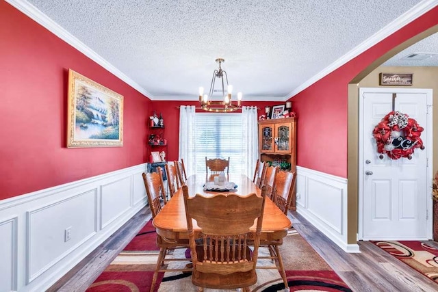835 Custom Ln, Winder, GA 30680 - dining room with wood finished floors, a chandelier, a textured ceiling, a decorative wall, and ornamental molding