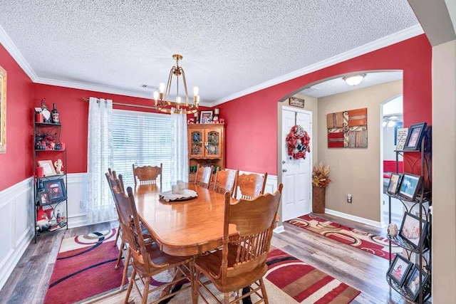 835 Custom Ln, Winder, GA 30680 - dining room featuring arched walkways, wood finished floors, a chandelier, a textured ceiling, and ornamental molding