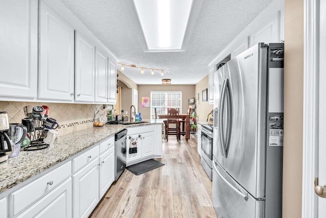 835 Custom Ln, Winder, GA 30680 - kitchen featuring appliances with stainless steel finishes, a textured ceiling, white cabinetry, light wood finished floors, and a sink