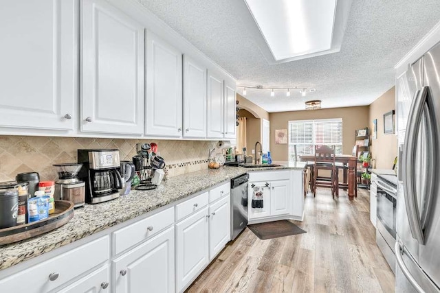 835 Custom Ln, Winder, GA 30680 - kitchen featuring appliances with stainless steel finishes, a sink, a textured ceiling, light wood-style floors, and white cabinetry