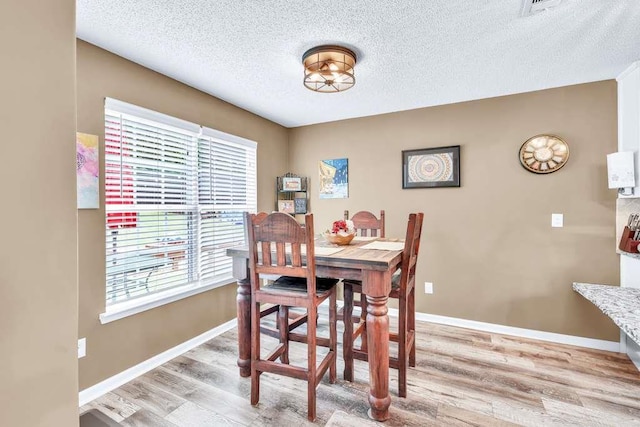 835 Custom Ln, Winder, GA 30680 - dining space featuring plenty of natural light, light wood-type flooring, a textured ceiling, and baseboards