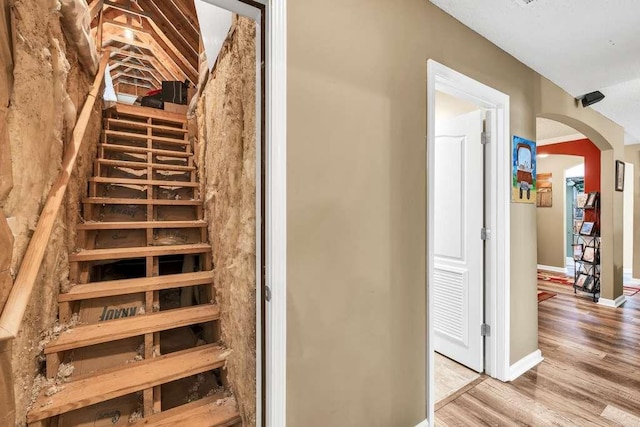 835 Custom Ln, Winder, GA 30680 - staircase with arched walkways, wood finished floors, baseboards, and vaulted ceiling