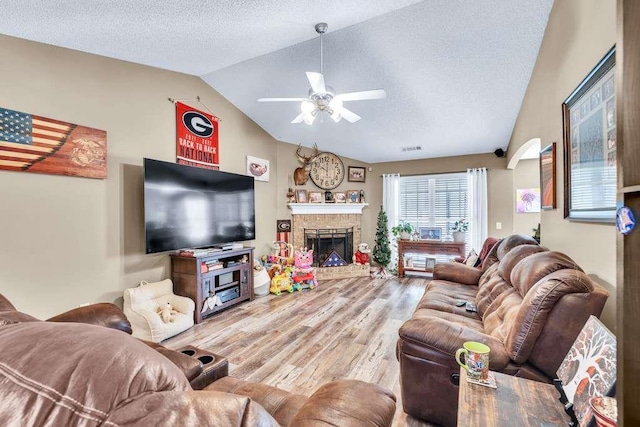 835 Custom Ln, Winder, GA 30680 - living room with lofted ceiling, ceiling fan, wood finished floors, a textured ceiling, and a fireplace
