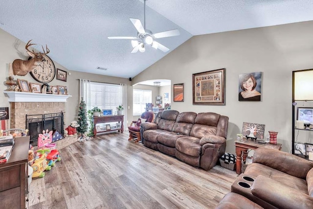 835 Custom Ln, Winder, GA 30680 - living area with a ceiling fan, a textured ceiling, a brick fireplace, arched walkways, and wood finished floors