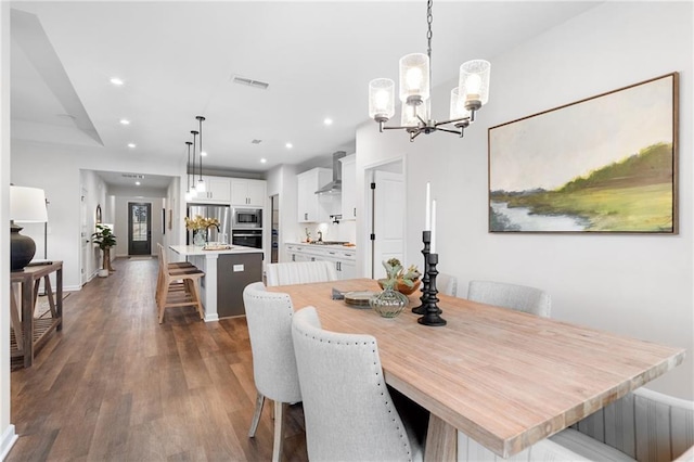 dining room with sink, a chandelier, and dark hardwood / wood-style floors