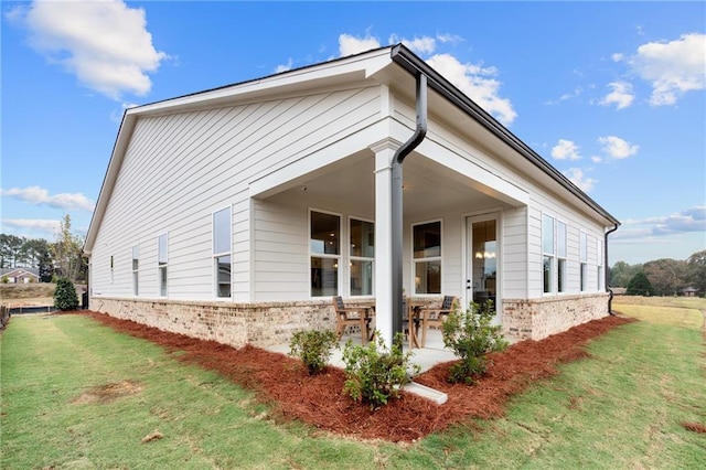 view of property exterior featuring a patio area and a lawn