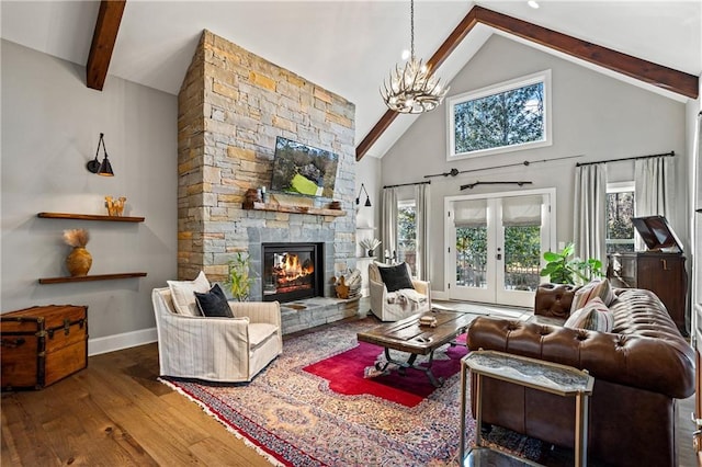 living room with french doors, a stone fireplace, a notable chandelier, hardwood / wood-style flooring, and beam ceiling