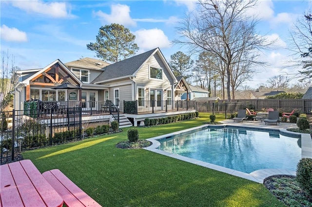 view of pool featuring a wooden deck, a patio, and a lawn