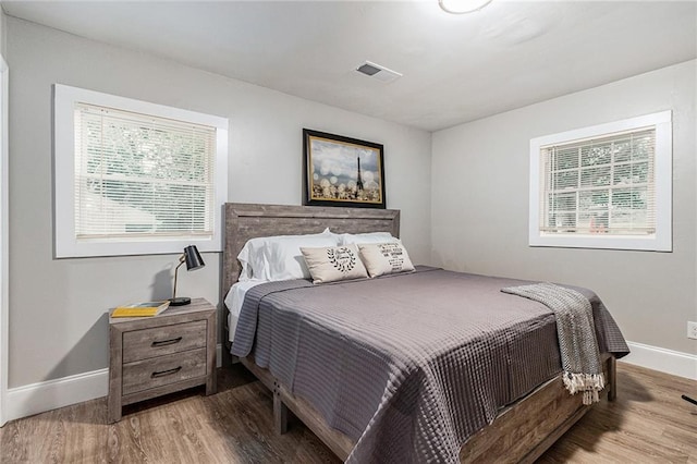 bedroom with light hardwood / wood-style flooring and multiple windows