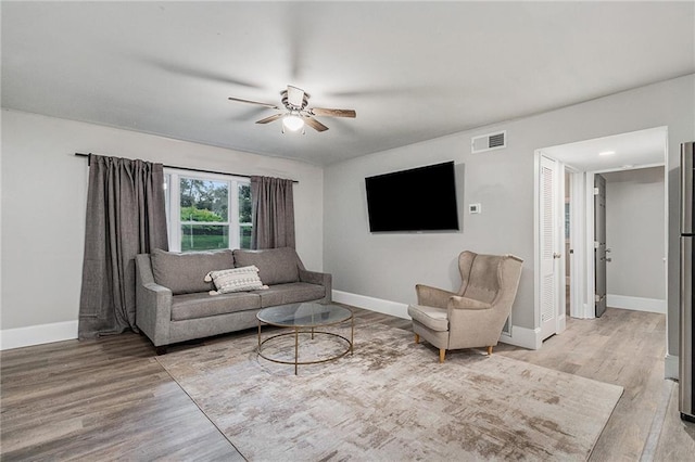 living room with ceiling fan and light wood-type flooring