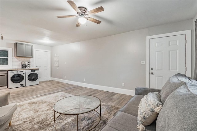 living room with separate washer and dryer, ceiling fan, and light hardwood / wood-style floors