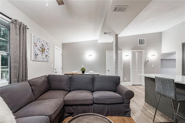 living room featuring ceiling fan, light hardwood / wood-style floors, and vaulted ceiling