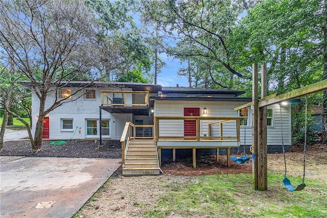 rear view of house featuring a wooden deck