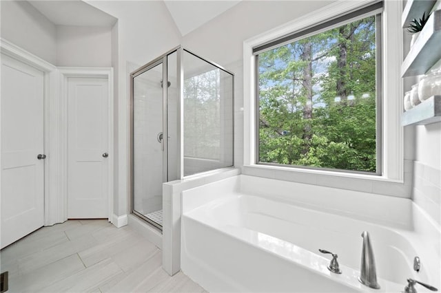 bathroom with plenty of natural light, tile patterned floors, a garden tub, and a shower stall
