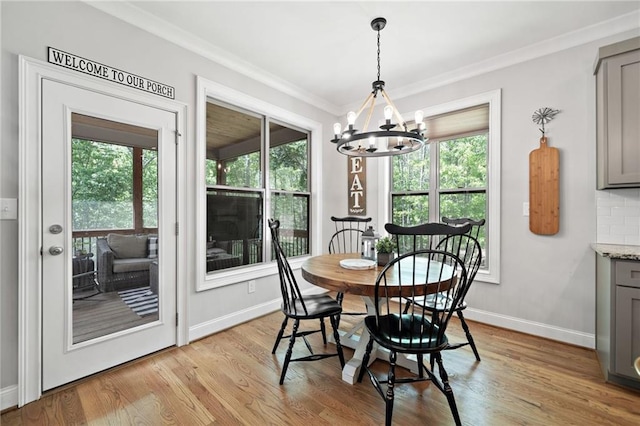 dining room with a chandelier, a healthy amount of sunlight, and light wood-style flooring