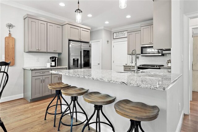 kitchen featuring gray cabinetry, appliances with stainless steel finishes, ornamental molding, and decorative backsplash