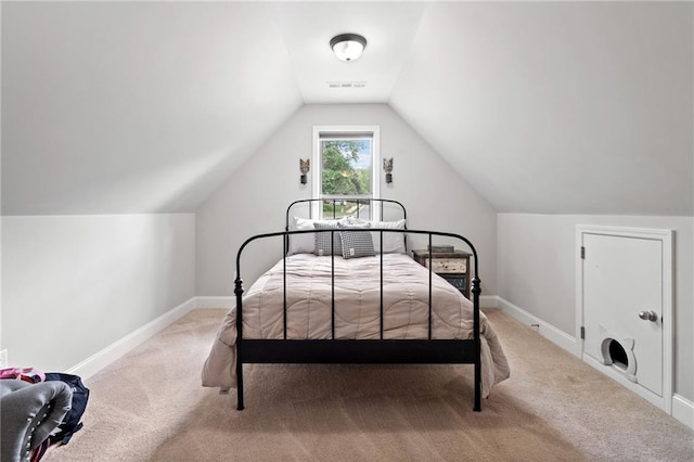 bedroom featuring baseboards, lofted ceiling, and light colored carpet