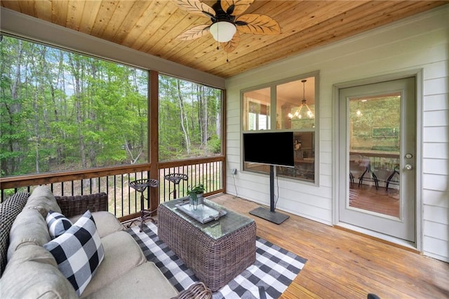 sunroom / solarium featuring outdoor lounge area and ceiling fan with notable chandelier