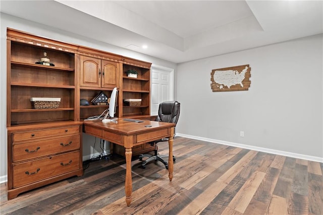 office area with recessed lighting, baseboards, a tray ceiling, and dark wood-style floors
