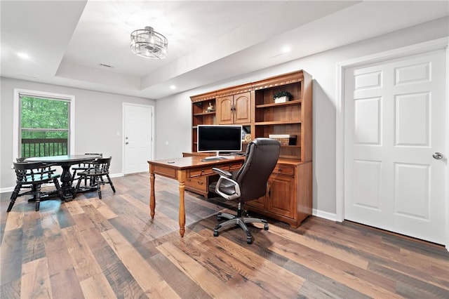 office area featuring recessed lighting, baseboards, wood finished floors, and a raised ceiling