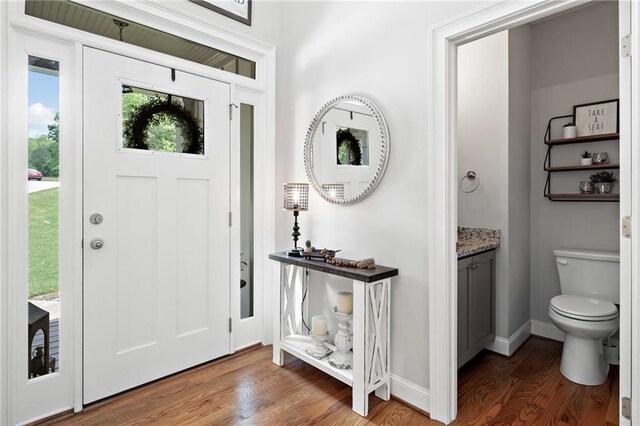 foyer entrance featuring baseboards and wood finished floors