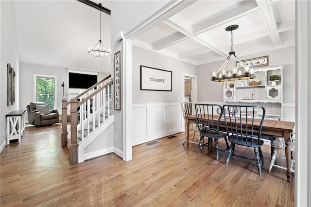 dining room with an inviting chandelier, wood finished floors, and coffered ceiling