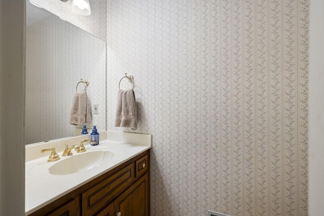 bathroom with wallpapered walls and vanity