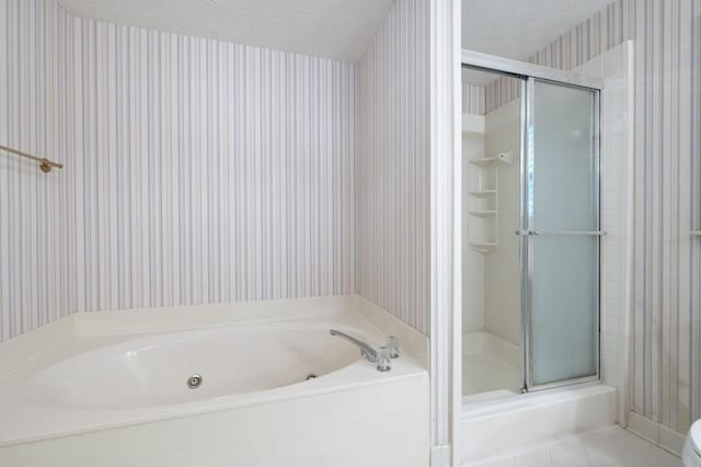 bathroom featuring wallpapered walls, a stall shower, a whirlpool tub, a textured ceiling, and tile patterned flooring
