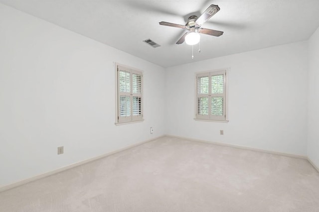 carpeted spare room featuring plenty of natural light, ceiling fan, and baseboards