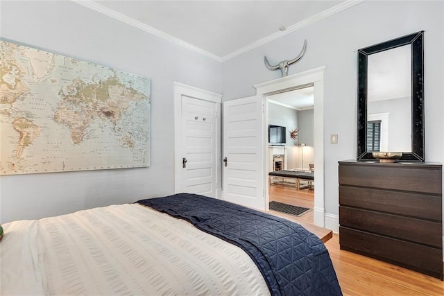 bedroom with light hardwood / wood-style floors and ornamental molding