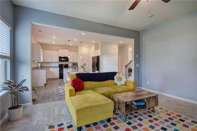 living room with light hardwood / wood-style floors and ceiling fan