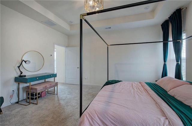 carpeted bedroom with a raised ceiling