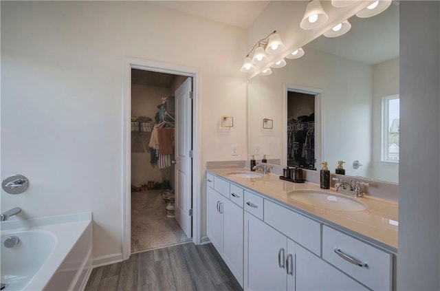 bathroom with a tub to relax in, vanity, and hardwood / wood-style floors