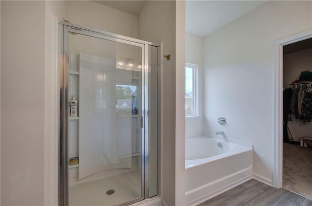 bathroom with wood-type flooring and independent shower and bath