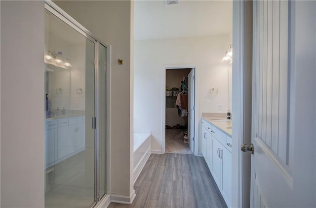 bathroom featuring hardwood / wood-style flooring, vanity, and shower with separate bathtub