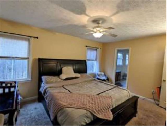 carpeted bedroom featuring ceiling fan and ensuite bathroom