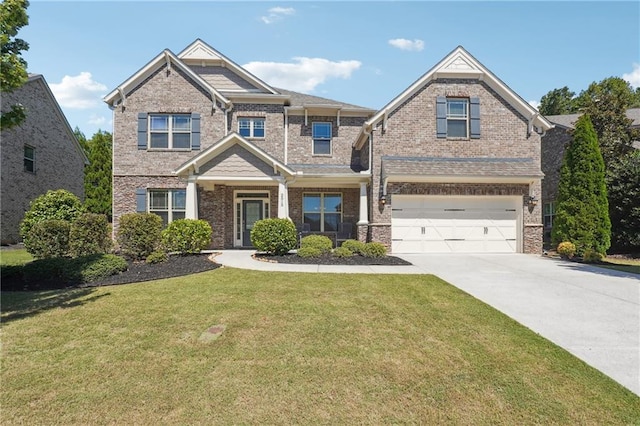 craftsman house with a front lawn, an attached garage, brick siding, and driveway