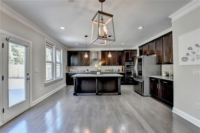 kitchen with a center island, dark brown cabinetry, light countertops, appliances with stainless steel finishes, and wall chimney exhaust hood