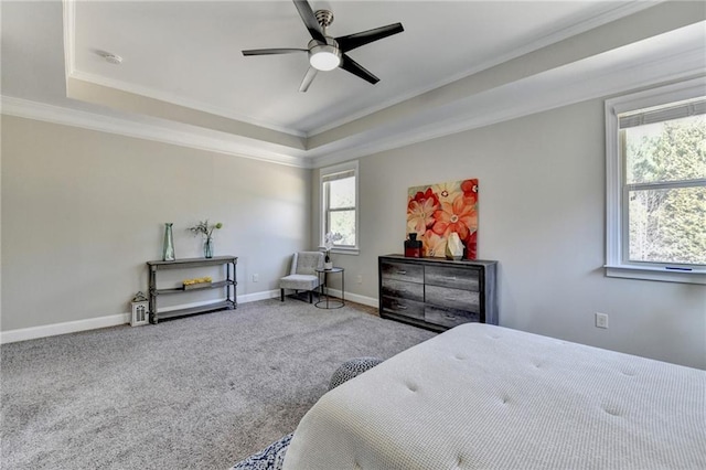 carpeted bedroom featuring crown molding, a ceiling fan, a raised ceiling, and baseboards