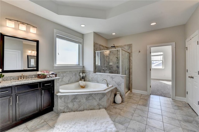 bathroom with a wealth of natural light, a shower stall, a bath, and vanity