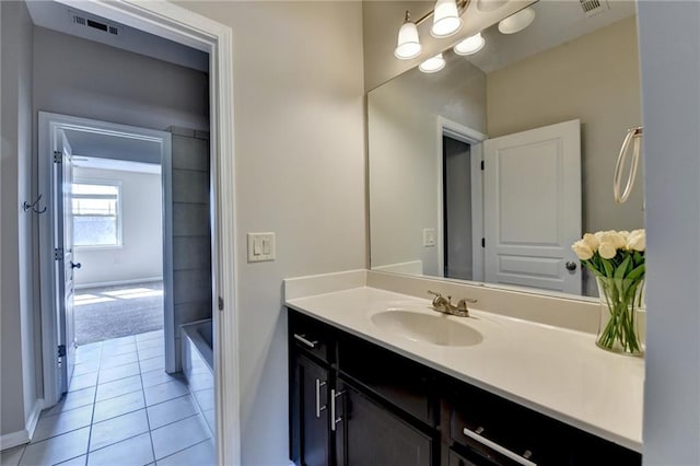 bathroom featuring vanity, visible vents, tile patterned flooring, and a washtub