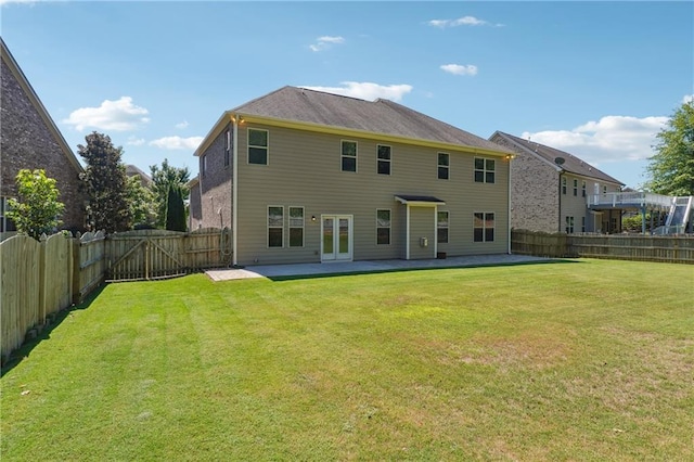 rear view of house with a patio area, a fenced backyard, and a yard