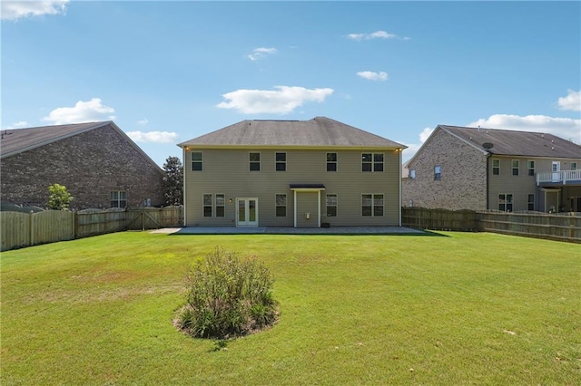 rear view of house featuring a patio, a lawn, and a fenced backyard