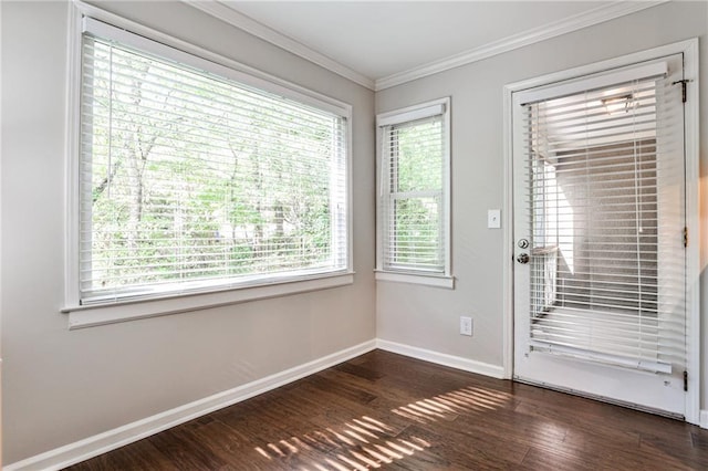 empty room with ornamental molding, dark wood-style flooring, and baseboards