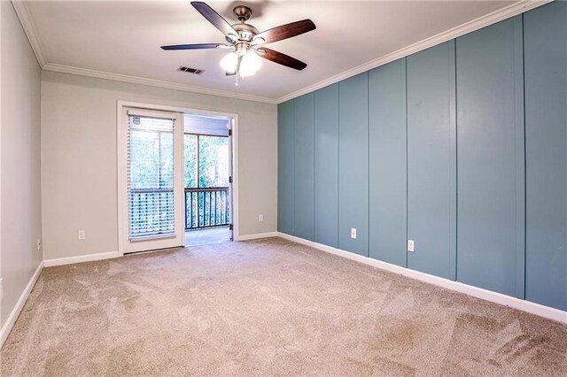 empty room featuring crown molding, visible vents, carpet flooring, ceiling fan, and baseboards